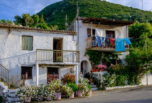 A beautiful greek house up a hill surrounded wirh blooming flowers, Corfu, Greece.