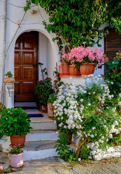 A beautiful greek house up a hill surrounded wirh blooming flowers, Corfu, Greece.