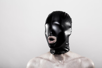 Mann mit schwarzer Maske auf dem Kopf mit Mundöffnung