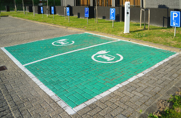Electric car and plug-in hybrid designated recharging point on car park.