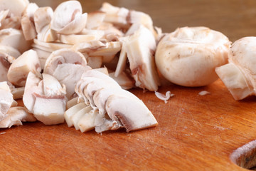 Champignon mushrooms sliced on wooden board