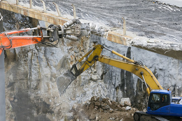  excavator demolition vehicle heavy equipment  tearing down  a bridge over the freeway in  aerial...