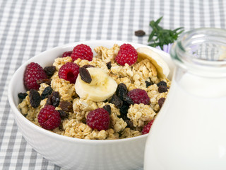 granola with fruits and bottle of fresh milk