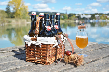 Beer bottles in the vintage basket on a wooden pier