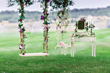 Wedding swing decorated with flowers - obrazy, fototapety, plakaty