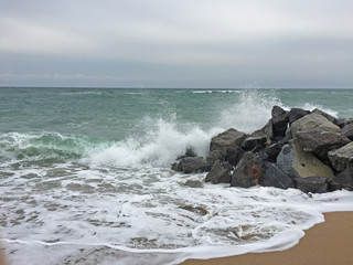 Fototapeta na wymiar Wellen brechen auf Steinen