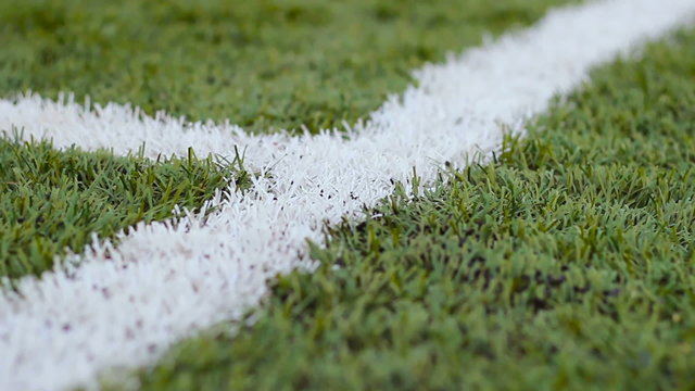 Close up  of the out of bounds  line on  a turf football field.