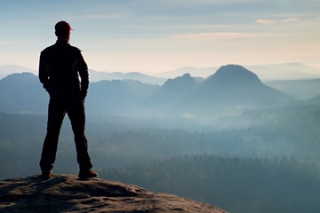 Hiker on sandstone rock in rock empires park and watching over the misty and foggy morning