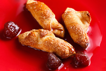 Homemade cookies with strawberry jam on a red plate