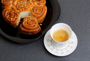 Cup of coffee and cinnamon bun with caramel syrup