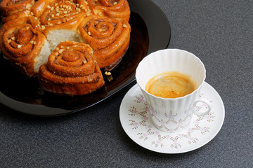 Cup of coffee and cinnamon bun with caramel syrup