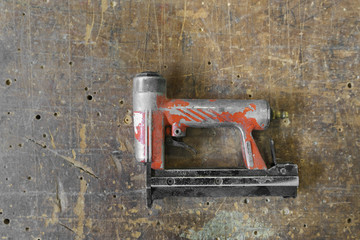 Old used red air nailer or nail gun carpenter tools