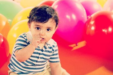 Fototapeta na wymiar Happy baby boy with yellow ballons