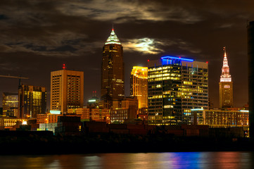Fototapeta na wymiar Full moon rising over downtown buildings in Cleveland Ohio