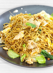Chinese fried noodle with pork , egg and green vegetable
