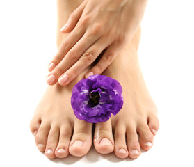 Female feet at spa pedicure procedure with flower isolated on white