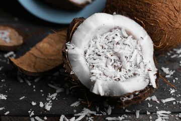 Coconut shavings in coconut on wooden background
