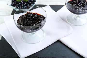 Tasty currant jam with berries on table close up