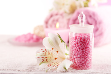 Spa treatment and flowers on wooden table, on light background