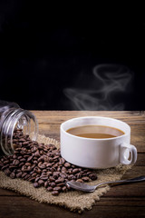 Coffee cup and beans on a wooden table.