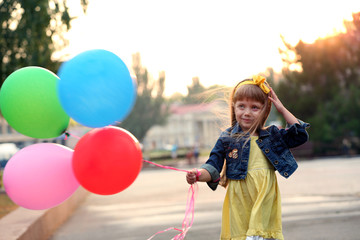 Little girl with balloons outside