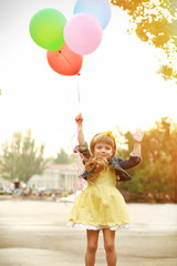 Little girl with balloons outside © Africa Studio