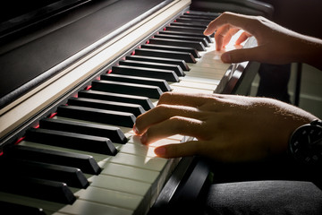 child's hands playing the piano