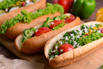 Hot dogs and vegetables on wooden cutting board