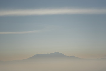 Foggy and volcano mountain during sunrise taken from Pinajagun II view point ,Indonesia.
