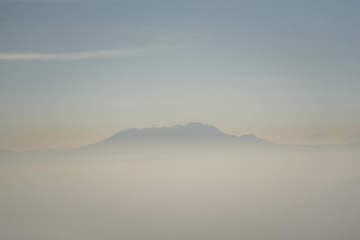 Fototapeta na wymiar Foggy and volcano mountain during sunrise taken from Pinajagun II view point ,Indonesia.