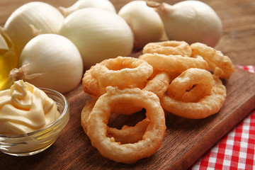 Chips rings with sauce and onion on cutting board closeup