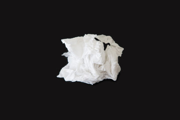Used screwed paper tissue isolated on dark background.