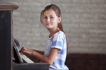 Cute little girl studding to play piano