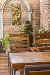 Wood table and Wood chair on a parquet wooden floor - brick wall background