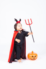 devil girl in black suit and red cape  with halloween pumpkin an