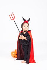 devil girl in black suit and red cape  with halloween pumpkin an