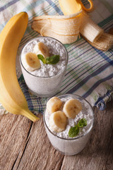 Delicious healthy yogurt with chia seeds and banana in a glass. vertical
