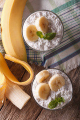 pudding with chia seeds and banana in a glass close-up. vertical top view
