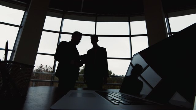 Business meeting: Silhouettes of two businessmen