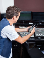 Man Holding Headphones While Sitting At Mixing Table