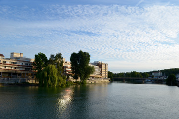 Fototapeta na wymiar Trees and buildings on shore of river Marne in French city Meaux
