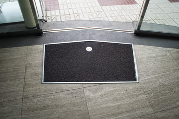 Black mat on the gray stone floor near glass sliding door
