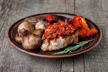 grilled vegetables and steak on a clay plate