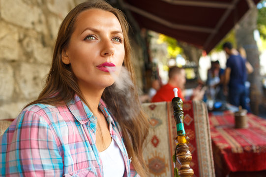 Woman smoking a shisha and relaxing in the cafe, Istanbul, Turke