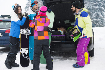 Group of friends preparing for snowboard