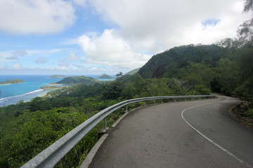 Road, sky, blue sea and islands on Mahe. Seychelles