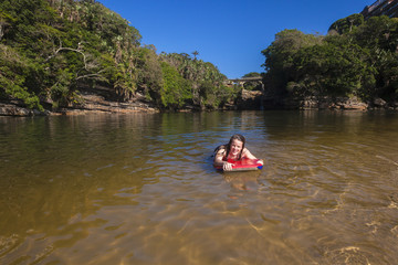 Girl swimming with board in river beach lagoon