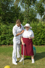 Senior Woman Standing With Crutch At Physiotherapy