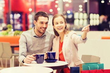 happy couple with shopping bags drinking coffee