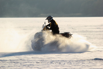 Quad bike's driver rides over frozen lake © aquatarkus